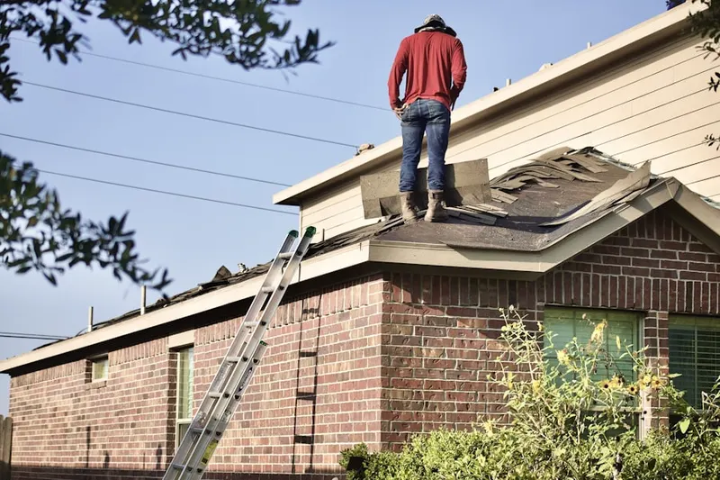 Professional roofer working on a residential roof in Seasons of East Meadow